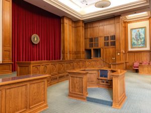 The inside of a court room with oak wood walls and furnishings